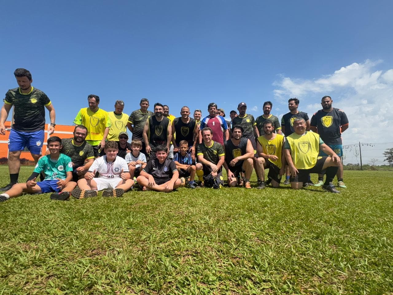 Associados e crianças reunidos no campo durante o dia
